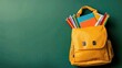 © wang - Yellow backpack filled with colorful pencils, books, and stationery on isolated green background, top-down view highlighting details, ideal for educational design, advertising banners, digital project
