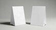 © MindRender - Two blank white folded table tent cards or signs displayed on a surface