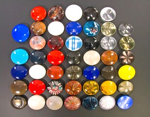 colorful assortment of round buttons arranged in a grid on a dark surface