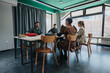 © qunica.com - Group of colleagues collaborating and discussing ideas in a well-lit office environment. The atmosphere is productive, fostering creativity and teamwork, with participants seated around tables.
