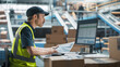 © Gorodenkoff - Male Stocking Associate Checking Inventory On Desktop Computer In Warehouse Facility With Automated Conveyor Belt. Sorting Center Employees Carrying Boxes to Package Products, Deliver to Clients.