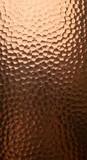 Rich hammered copper texture with warm metallic sheen and deep shadow play for luxurious design applications