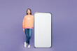 © ViDi Studio - Full body young smiling woman she wear yellow sweatshirt casual clothes big huge blank screen mobile cell phone smartphone with area look camera isolated on plain purple background. Lifestyle concept