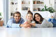 © ty - Young Caucasian family with small daughter pose relax on floor in living room, smiling little girl kid hug embrace parents, show love and gratitude, rest at home together.