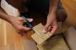 © dikushin - Close-up of gardener cutting piece of rockwool with scissors, preparing it for seed starting in hydroponic system, demonstrating process of indoor gardening. Concept of healthy cultivation.