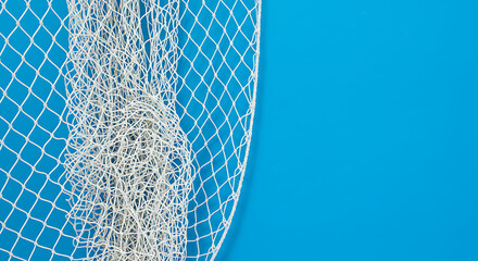 Fishing net with a white rope on a blue background, top view with copy space