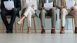 © Ol - The candidates waiting with paperwork for an important job interview in an office setting.