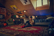 © master1305 - Teen boy reading notebook in retro attic bedroom. Concept of education, creativity, personal space, and emotional growth with nostalgic 90s room decor.