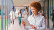 © Monkey Business - Smiling Female High School Or Secondary Teacher With Digital Tablet Outdoors At School