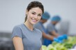 © InkCrafts - Smiling woman working in a modern kitchen, preparing fresh vegetables for a healthy meal.