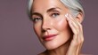 © wiwat02 - Portrait of a Beautiful Mature Woman Applying Skincare Cream on Her Face with a Serene Smile