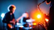 © MarkelovaVision - Dramatic close-up of a saxophone illuminated against a band performing on stage with colorful lights.