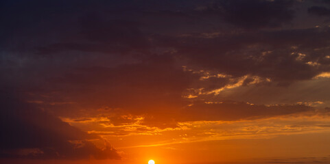 Wall Mural - Bright orange sunset sky background with dramatic clouds.