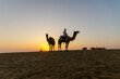 © cn0ra - Indian Man Riding Camel During Sunrise at Thar Desert in Rajasthan, India