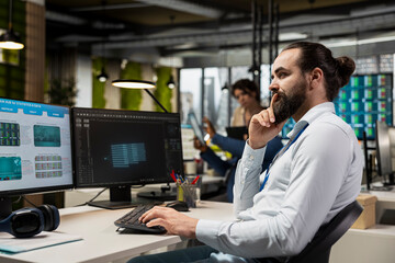 IT engineer reviewing data analysis results with artificial intelligence, integrating machine learning and automation tools to enhance productivity with dual monitors in the office.