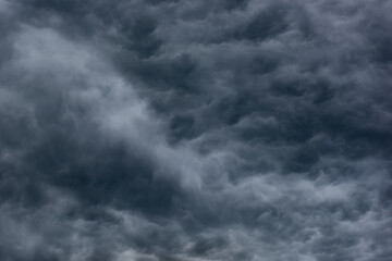 Wall Mural - stormy dramatic textured sky. thick billowing grey impenetrable clouds. artistic photo of natural cloudscape for moody background or backdrop