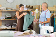 © JackF - Dissatisfied young woman client with sewn dress quarreling with elderly man tailor in sewing workshop