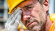 © ABF_MATEO - Sweaty worker wiping brow with gloved hand wearing safety hat, drenched in sweat after hard work under the hot summer sun.