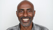 © Florian Dussart - A handsome, happy middle aged Black man with a grey beard smiling, white background