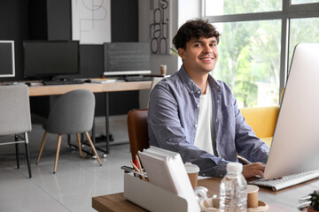male programmer working with computer at table in office