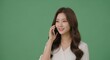 © Smallde - Smiling Woman Talking on Cellphone Against Green Backdrop