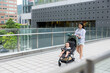 © leungchopan - Mother walk with her baby son on pram in city