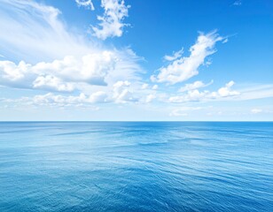 Wall Mural - Blue waves reflect the summer sunlight, painting a serene seascape where the ocean meets the horizon under a vast, cloudy sky