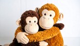 Two plush monkey toys hug affectionately against a white background
