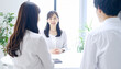 © Hiroshi - Asian Female Instructor Giving Skincare Training to Small Group, Including Businessman in Suit