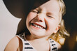 © nataliaderiabina - Cutest little girl smiling and squinting in sunlight. Happy toddler having fun. Portrait of playful child preschool age. Lifestyle photography.