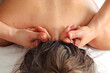 © Raquel - Close-up view of a professional therapist performing a neck massage on a client lying face down, focusing on relaxation, stress relief, and muscle tension release in a calm.