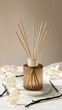 © Alena - Elegant scent diffuser surrounded by vanilla pods and white flowers on a light marble background