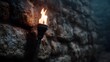 © Thares2020 - Flaming torch illuminating an ancient stone wall