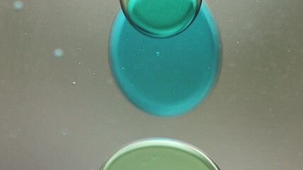 Wall Mural - Close-up of blue and green liquid with floating bubbles and blobs in motion inside a lava lamp, viewed in a horizontal orientation. Hypnotic and abstract visual texture.