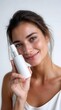 © Studio Zenith - Femme souriante presentant un flacon de serum cosmetique blanc