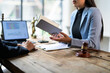 © PaeGAG - Lawyer holding document is explaining legal advice to client in office