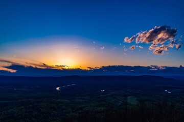 Wall Mural - sunset over a vast landscape with blue sky and clouds.