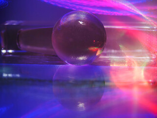 Wall Mural - a clear glass ball is sitting on a pedestal. colorful background. abstract graphic background. light
