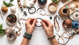 Pebbles, threads, jewelry making materials, hands making a bracelet, white background, top view.