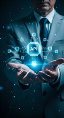 businessman in gray suit holding a glowing digital api icon with network connections. concept of sof