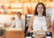 © JackF - Young woman carrying tray with coffee cups to table in cafe