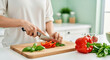 © Bakha - Woman chopping fresh red bell pepper and basil on wooden cutting board in bright modern kitchen healthy vegetarian meal preparation, clean eating and home cooking concept