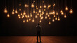 © Tohamina - Man looking up at many glowing hanging lightbulbs in a dark room