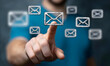 © sornram - A person interacts with digital email icons, symbolizing communication. The image captures a modern approach to managing messages in a digital world.