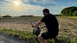 © fotoworld - Sunlit cyclist rides past a whispering field, evoking Lughnasadh reflections and serene pedal-powered meditation, tranquility unfolds