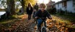 © adVance - Boy Riding Bike with Family in Autumn Park.