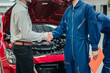 © Exnoi - Car owner shaking hands with professional mechanic in clean workshop, symbolizing successful repair, trust, and complete customer satisfaction in automotive service industry.