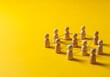 © RP AI - Wooden figures connected by lines on a yellow background, symbolizing teamwork, collaboration, and communication within a group or organization, representing interpersonal relationships and unity.