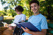 © zinkevych - Two teens in the park preparing for the lessons and reading a book