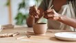 © Arief - Woman Painting Ceramic Bowl In Pottery Studio